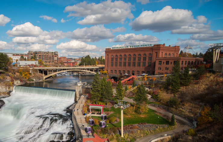 Spokane Falls rushing through Riverfront Park with city buildings in the background