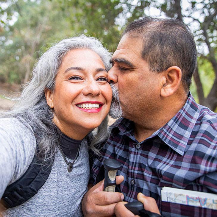 Man kissing his wife while hiking