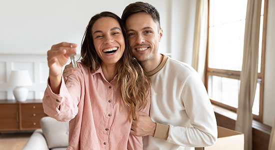 thumbnailfor Happy young couple holding keys to first house